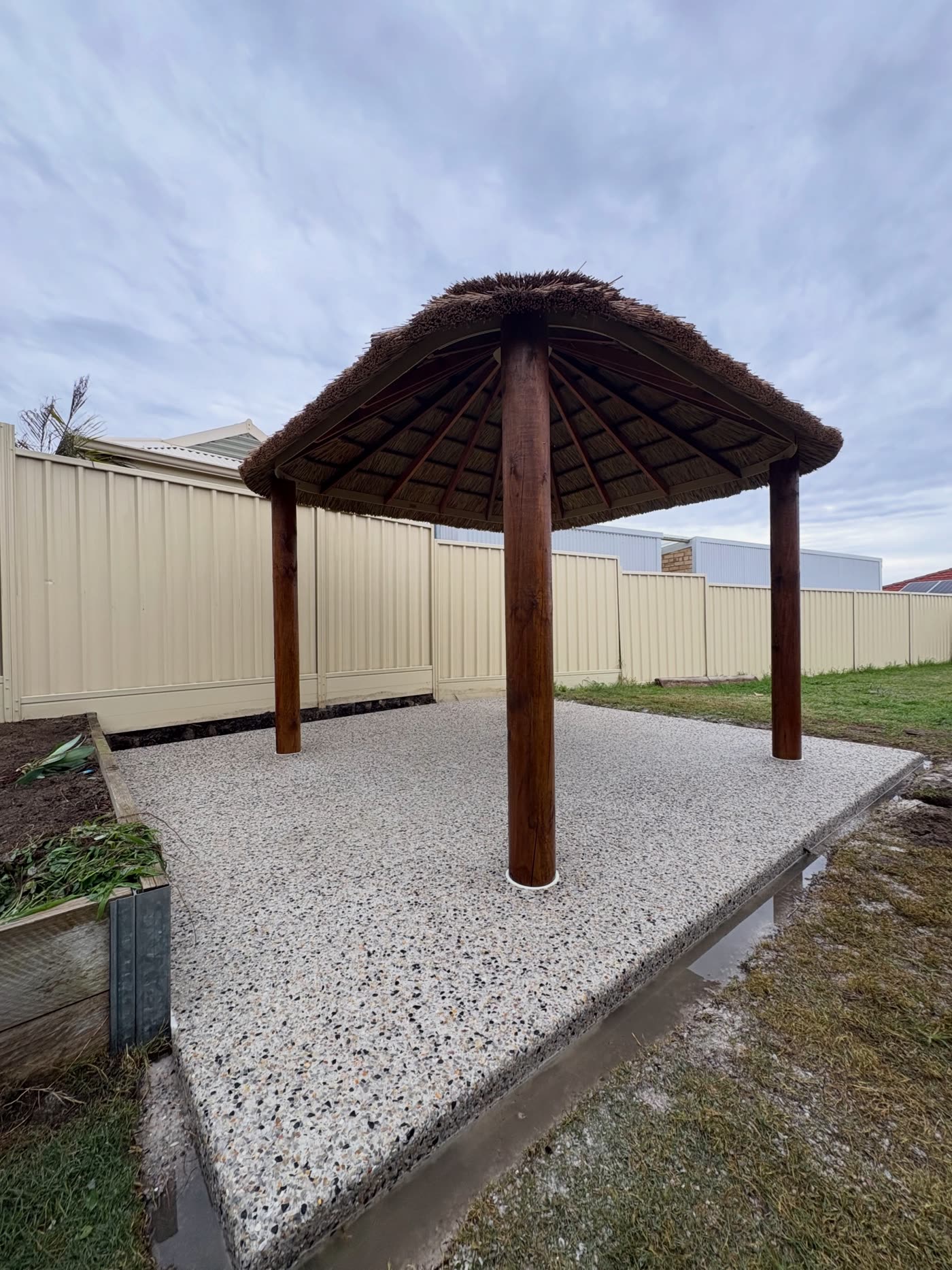 Completed alfresco pad with outdoor hut, exposed aggregate finish