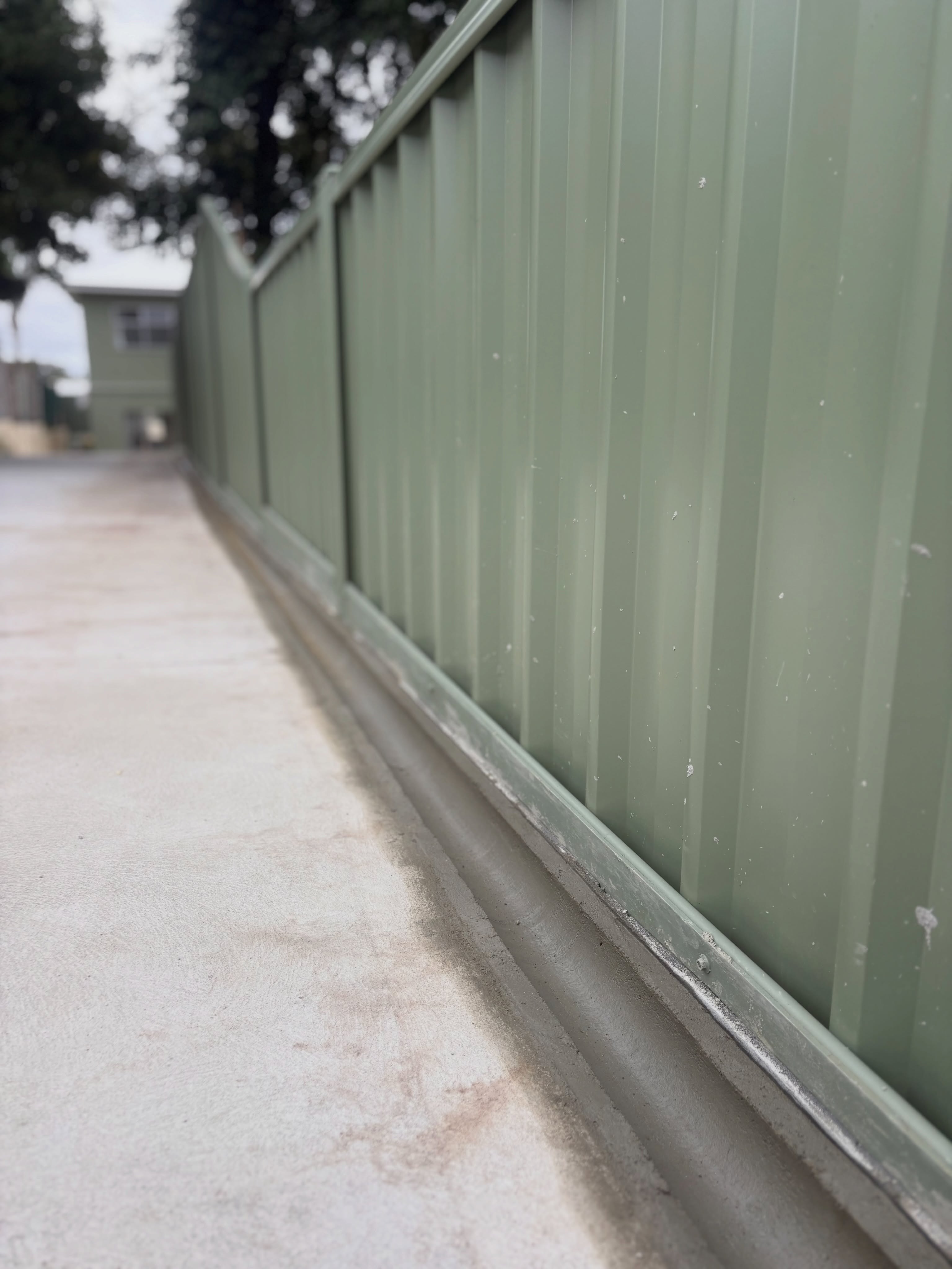 Concrete poured neat along a fence line on a weekend call-out