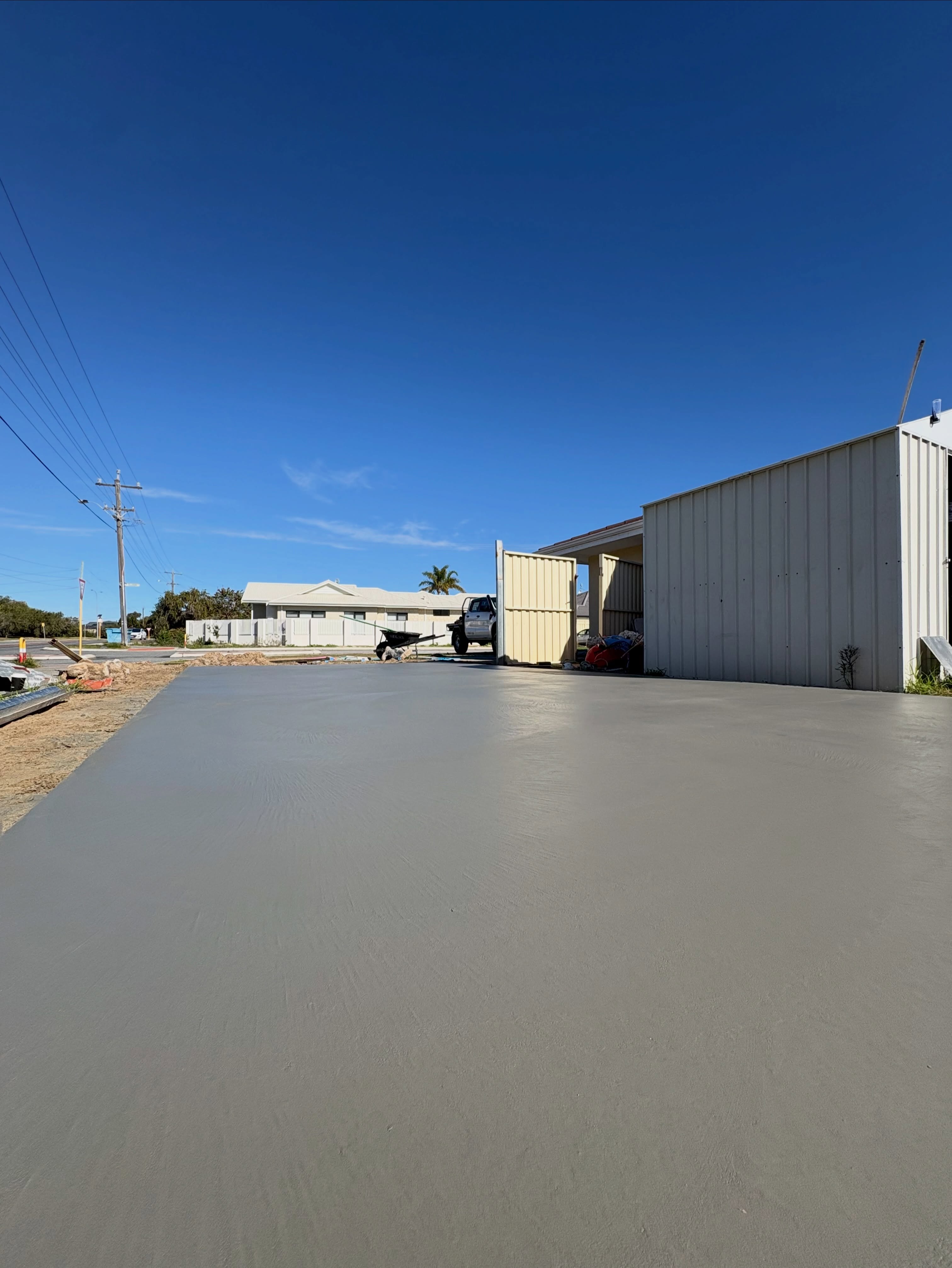 The same Padbury shed pad poured and floated, a clean grey slab ready for the shed